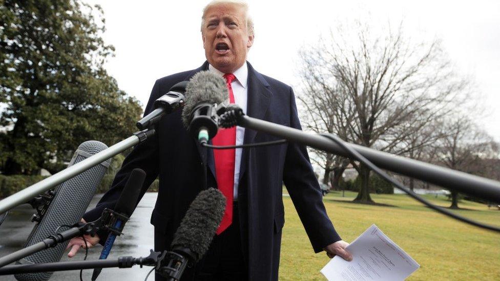 Donald Trump holds a copy of a court document prior to his departure from the White House