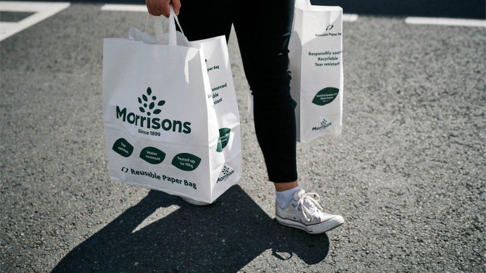 A woman carrying Morrison's bags