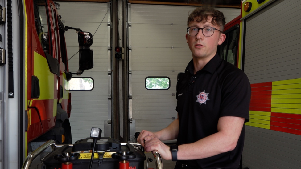 Anthony Seward checking equipment beside a fire engine