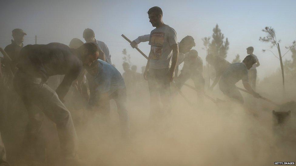 People prepare graves for the victims of an IS bomb in Suruc, Turkey on 21 July