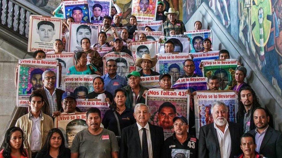 A handout photo released by the Mexican presidency shows President Andres Manuel Lopez Obrador (C down) posing for a picture with relatives of some of the 43 students who disappeared, at the Palacio Nacional, in Mexico City on 11 September 2019