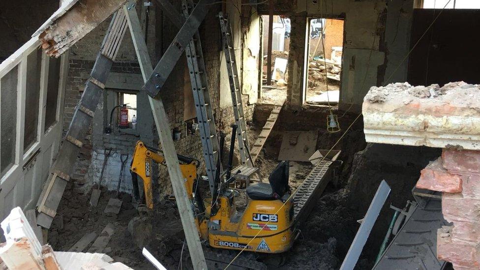 JCB digger inside collapsed house