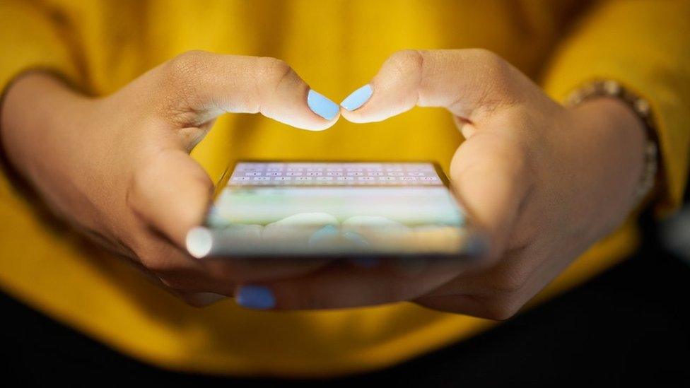 Woman typing on phone