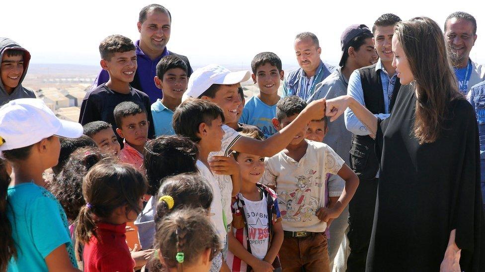 US actress and UN goodwill ambassador Angelina Jolie bump fists with a Syrian boy during her visit to Azraq Syrian refugee camp, 90 Km east of Amman, Jordan