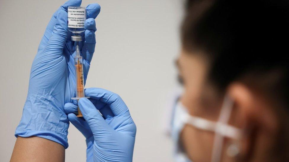 A health worker prepares an injection at a vaccination centre in Westfield Stratford City shopping centre