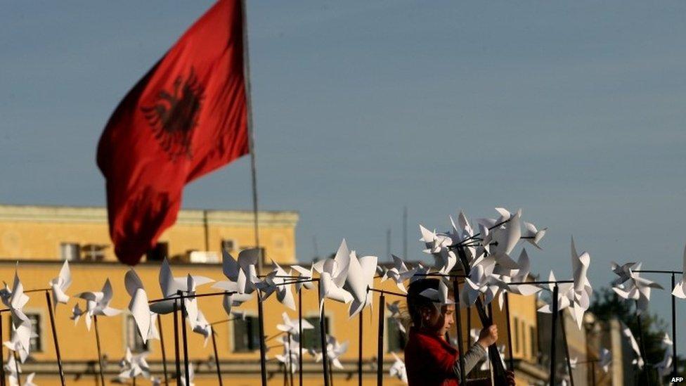 A girl plays with pinwheels in a square in the Albanian capital Tirana