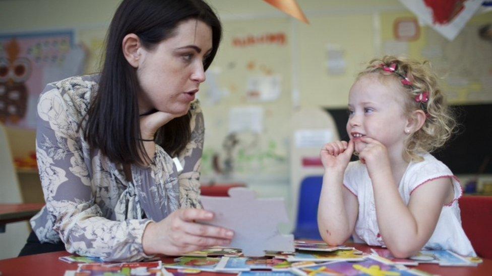 Woman teaching a child to read