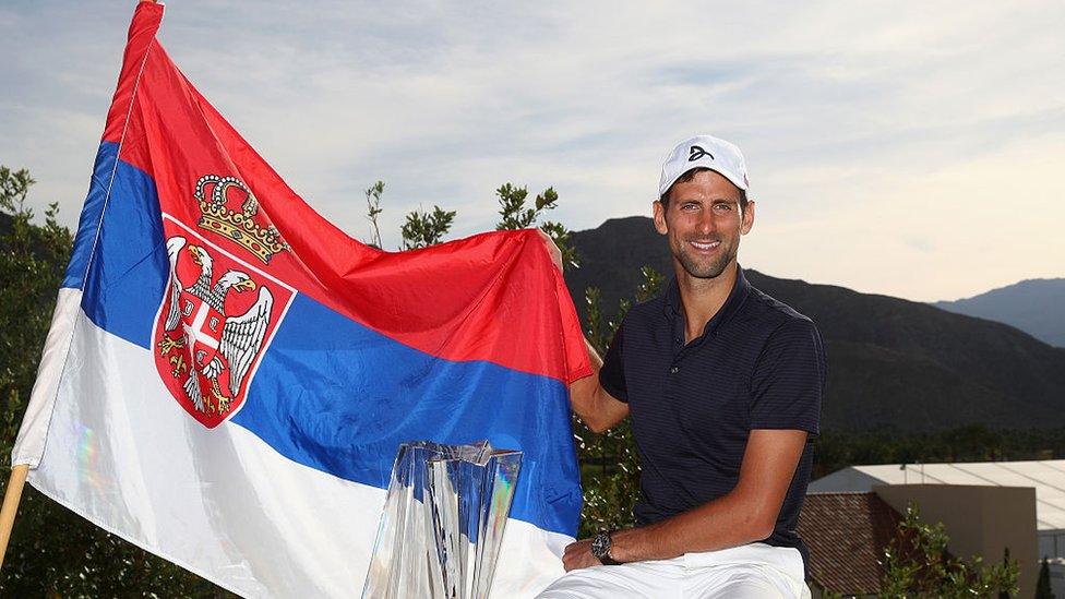 Novak Djokovic poses with a Serbian flag in 2016