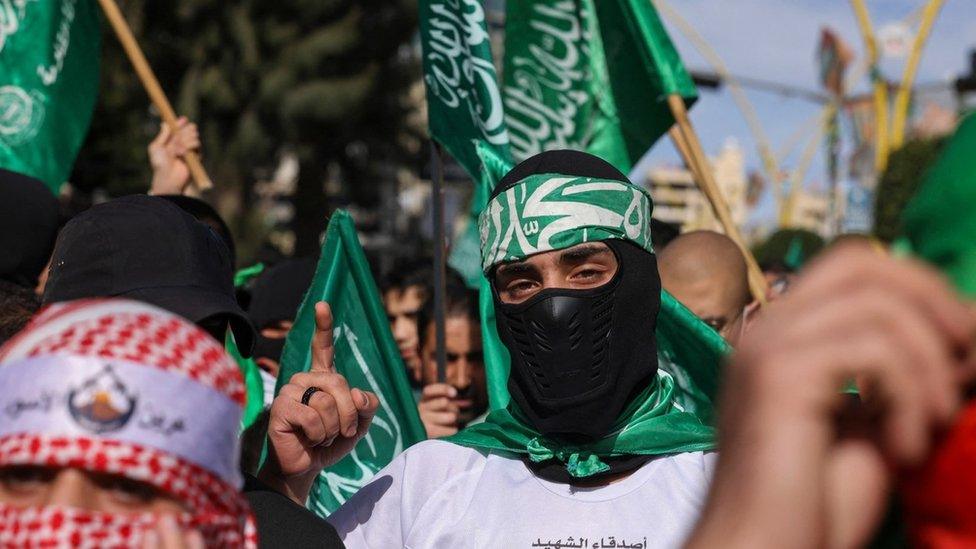 Demonstrators carry Hamas flags at a protest against the war in Gaza, after Friday prayers in Hebron, in the occupied West Bank (8 December 2023)