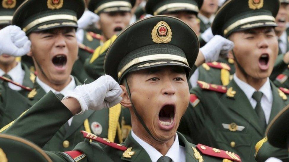 Paramilitary policemen and members of a gun salute team shout slogans at an oath-taking ceremony for the upcoming military parade to mark the 70th anniversary of the end of the World War Two, at a military base in Beijing, China, 1 September 2015