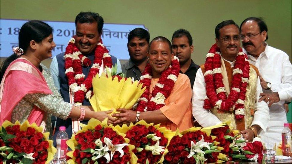 Senior Leader of India"s Bharatiya Janata Party (BJP) M. Venkaiah Naidu (R) Uttar Pradesh BJP Leaders Prasad Maurya (2L) and Dinesh Sharma (2R) look on as Yogi Adityanath (C) is presented with a floral bouquet during a ceremony in Lucknow on March 18, 2017,