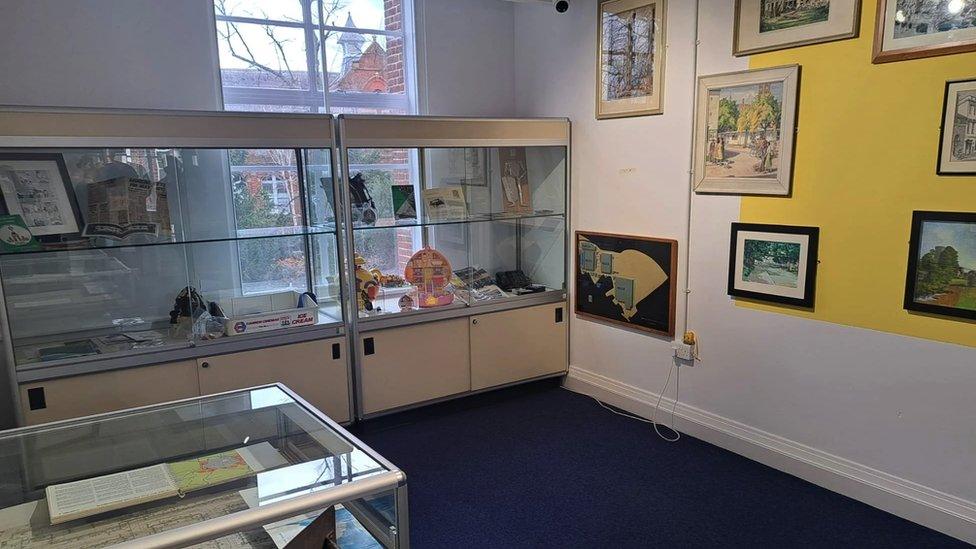 Image inside the new museum space. Artwork and display cabinets can be seen