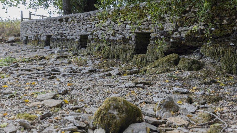 A bridge crosses the dried bed of the River Thames near the river's source at Thames Head,