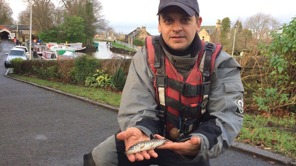 Peter Dennis holds a baby pike