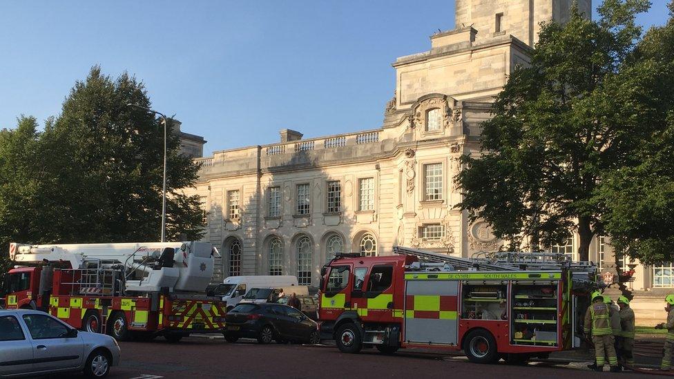 Firefighters wait outside city hall