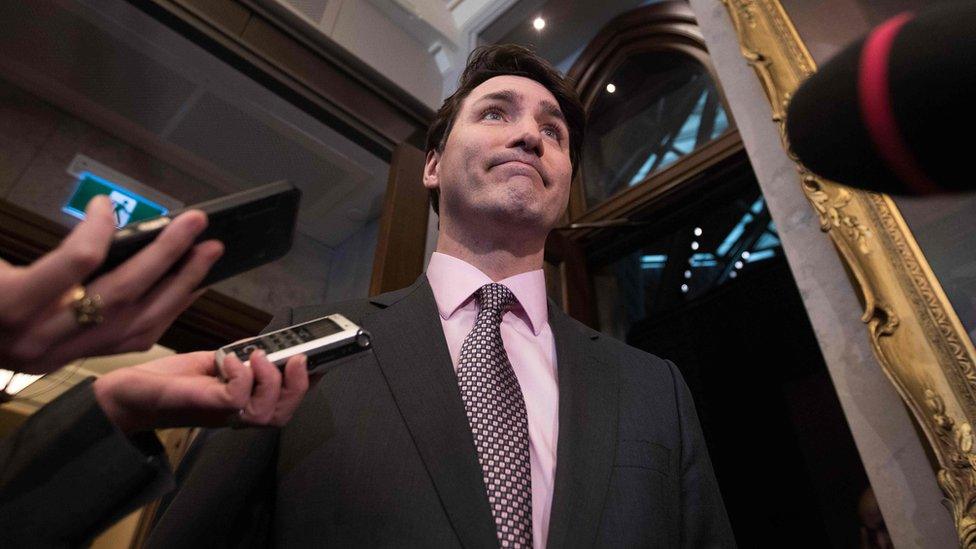 Canadian Prime Minister Justin Trudeau surrounded by microphones