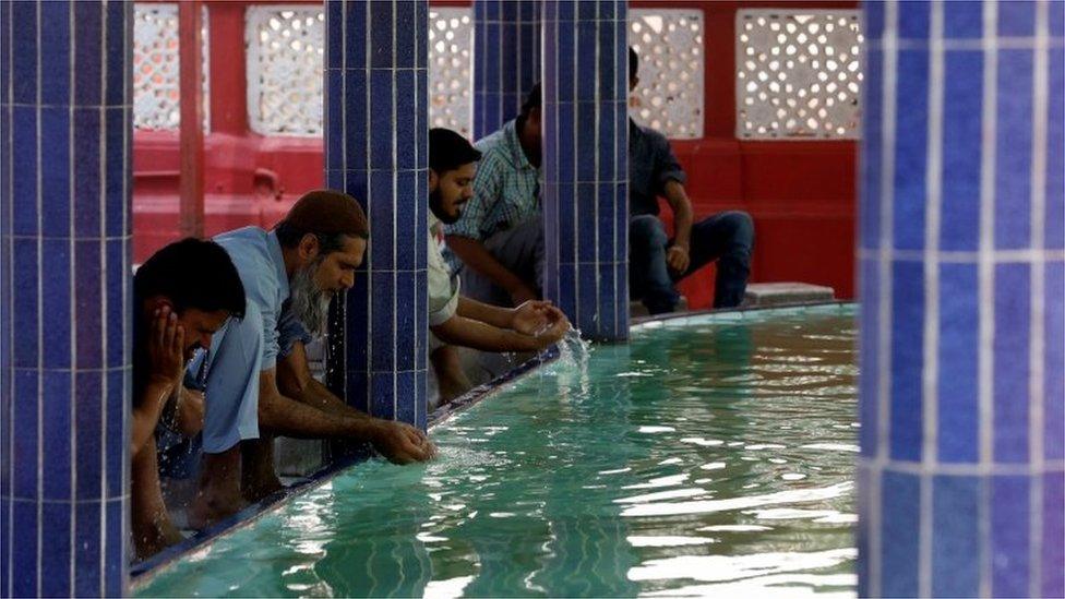 Muslims perform ablution as they gather to attend Friday prayer amid an outbreak of the coronavirus disease (COVID-19), at a mosque in Karachi, Pakistan March 20, 2020