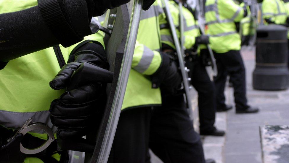 Police officers with shields in protective gear