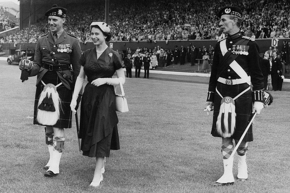 Queen Elizabeth with the officer in charge of the Guard of Honour of the 1st Battalion of the Glasgow Highlanders, during a Youth Rally at Hampden Park, Glasgow, during her state visit to Scotland, 25 June 1953