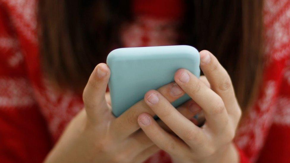 Close-up of hands holding phone