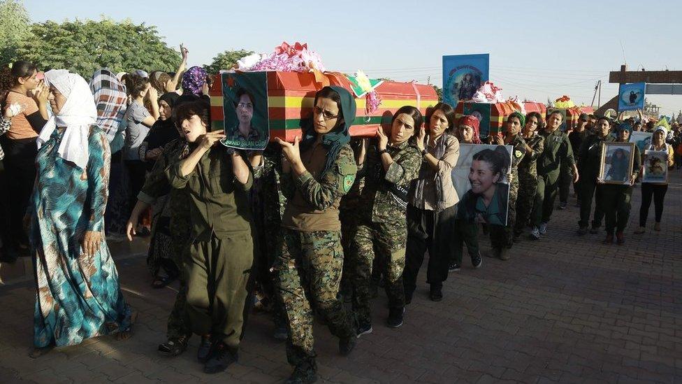 Syrian Kurd women fighters carry the coffin of a comrade killed in Manbij at a funeral in Qamishly, 13 August