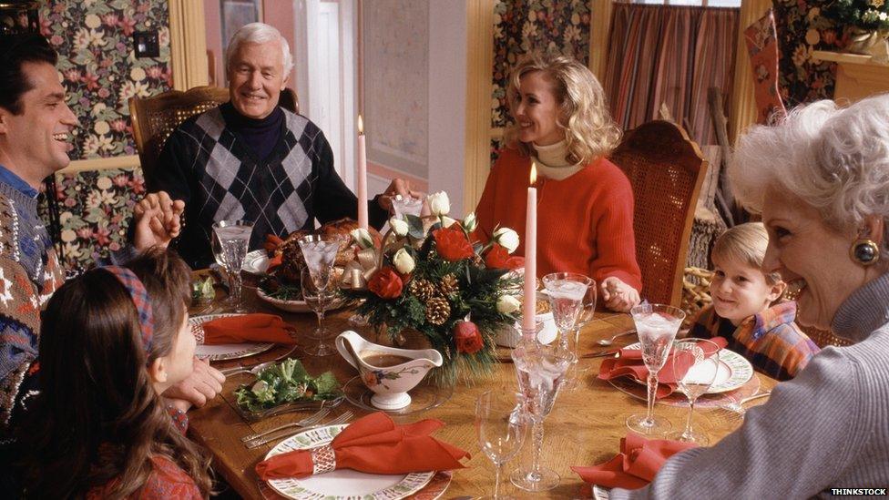 Family holding hands at the dinner table