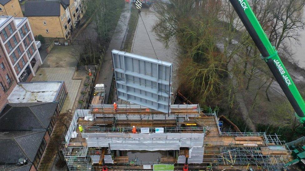 Flood gate being lowered by cranes