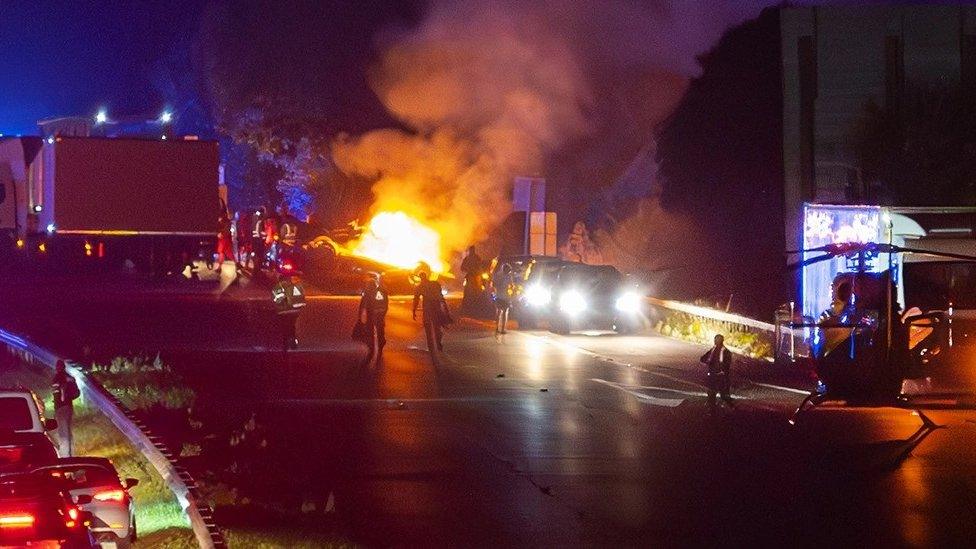 A two-vehicle crash on a motorway causes a car to overturn and set ablaze