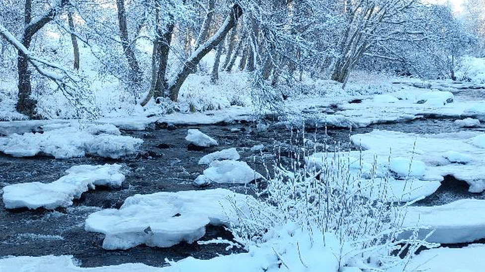 Snowy scene by riverside