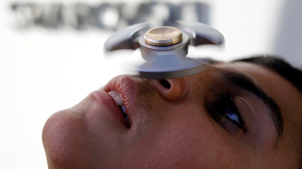 A boy performs tricks using a fidget spinner during a contest held in Israel