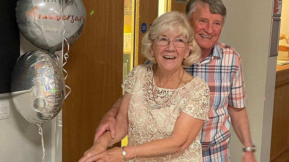 Gerry and his wife cutting a cake at their anniversary party.