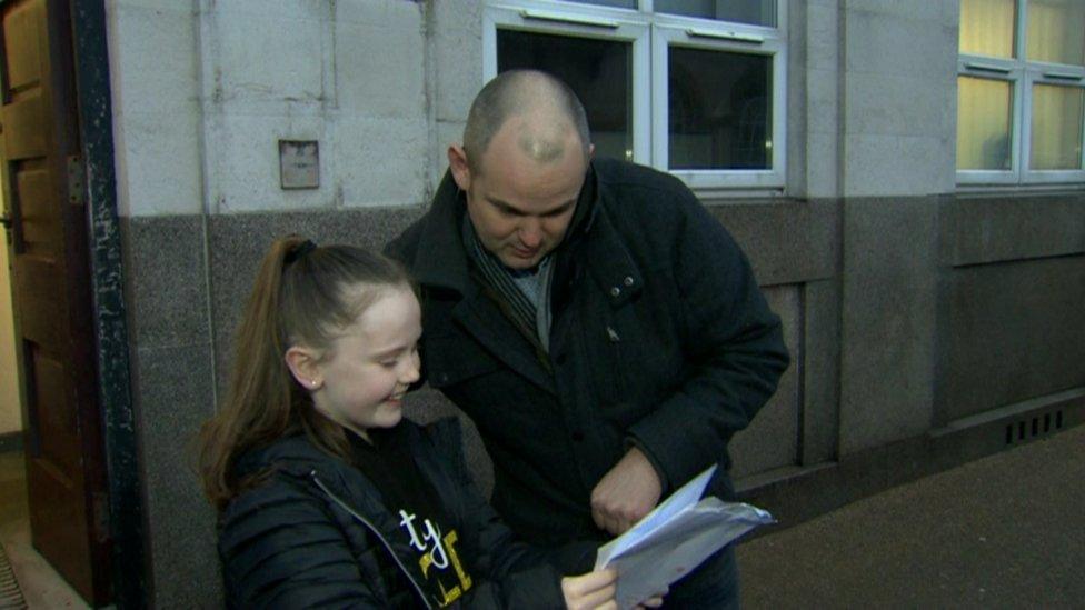 Lucy Morrison opening her results with her Dad outside the post office