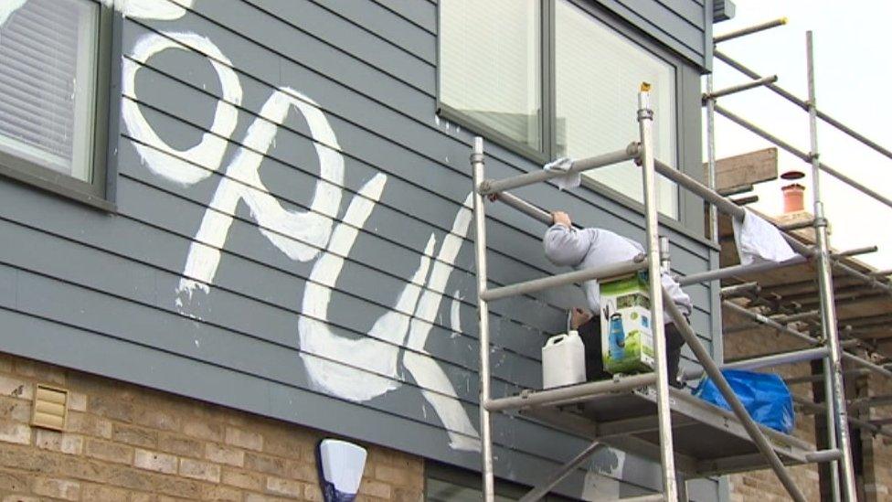 Latin graffiti being cleaned