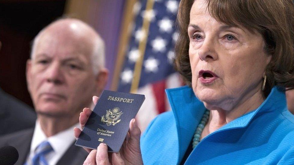 Senate Intelligence Committee Vice Chair Sen Dianne Feinstein, joined by Sen Ben Cardin, points to the embedded chip in her passport that contains digital information at a news conference in Washington on 19 November