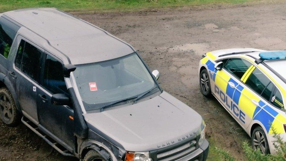 Land Rover left at the site next to police car