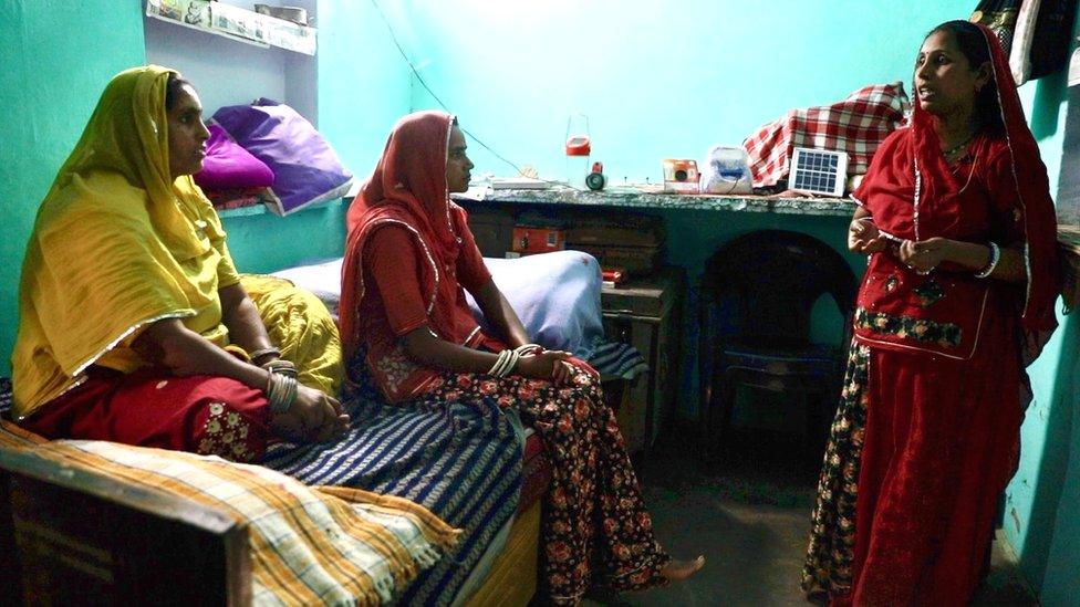 Santosh Kanwar (R) showing products to local villagers