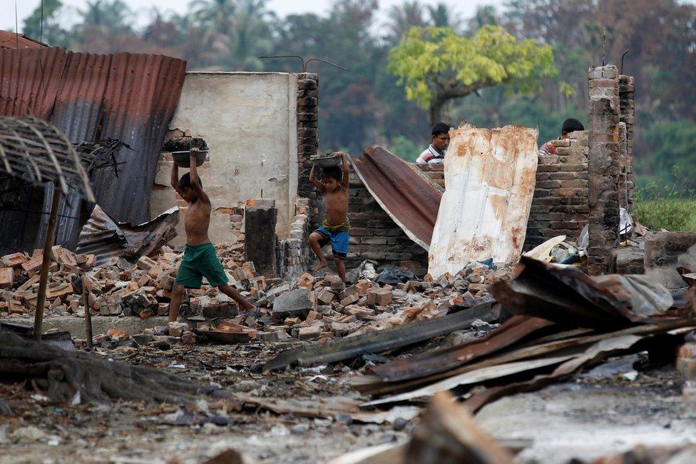 Children recycle goods from the ruins of a market which was set on fire at a Rohingya village outside Maugndaw in Rakhine state, Myanmar, 27 October