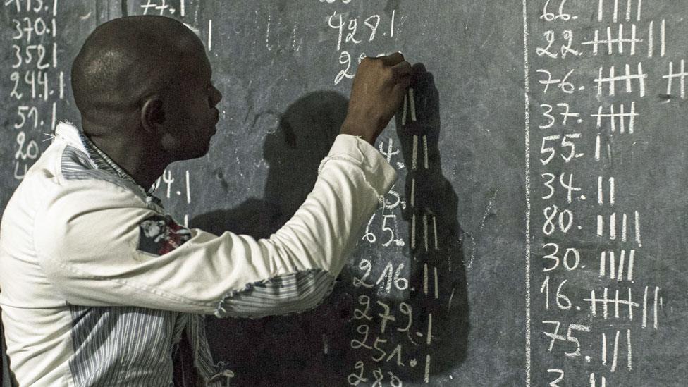 An election clerk counts votes at a polling station in Kinshasa, Democratic Republic of the Congo