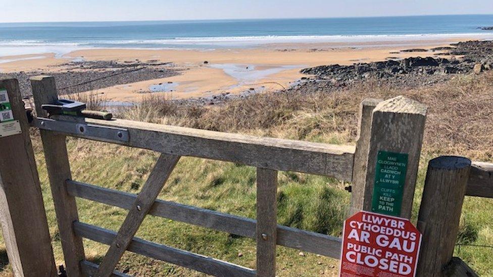 A closed sign on a coastal path gate