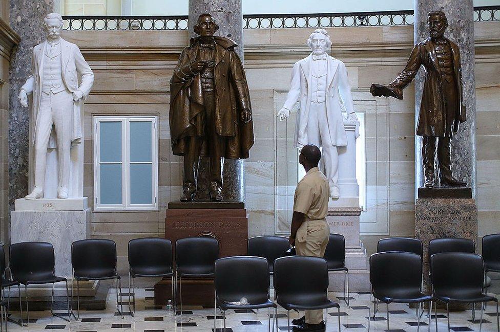 black man looks at confederate soldier