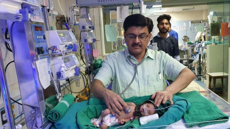 Dr Ravi Khanna with the baby in his hospital