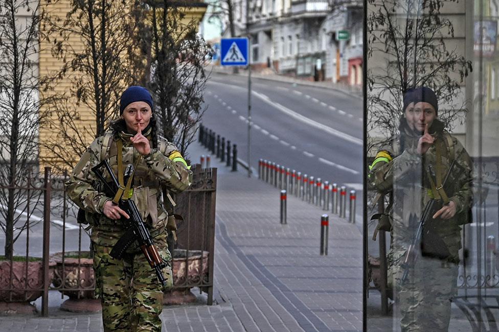 A member of Ukrainian forces patrols the streets at Maidan square in Kyiv on 27 February 2022