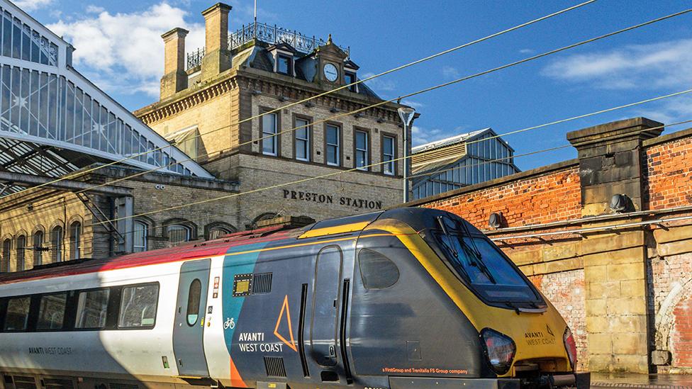 Train sat outside Preston rail station, with the station building in the background