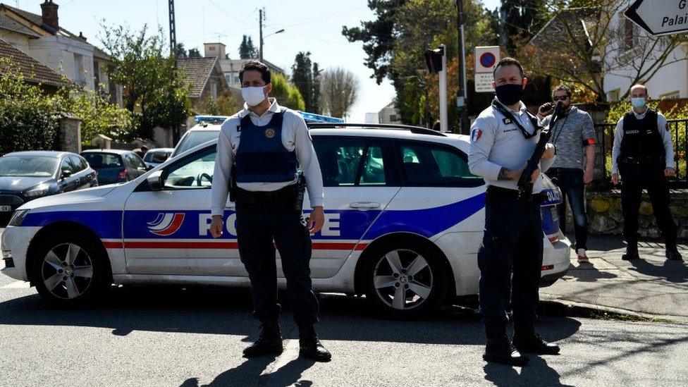 French police officials close a street near a police station in Rambouillet, south-west of Paris, on April 23