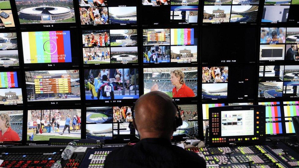 A TV director sat in front of lots monitor feeds