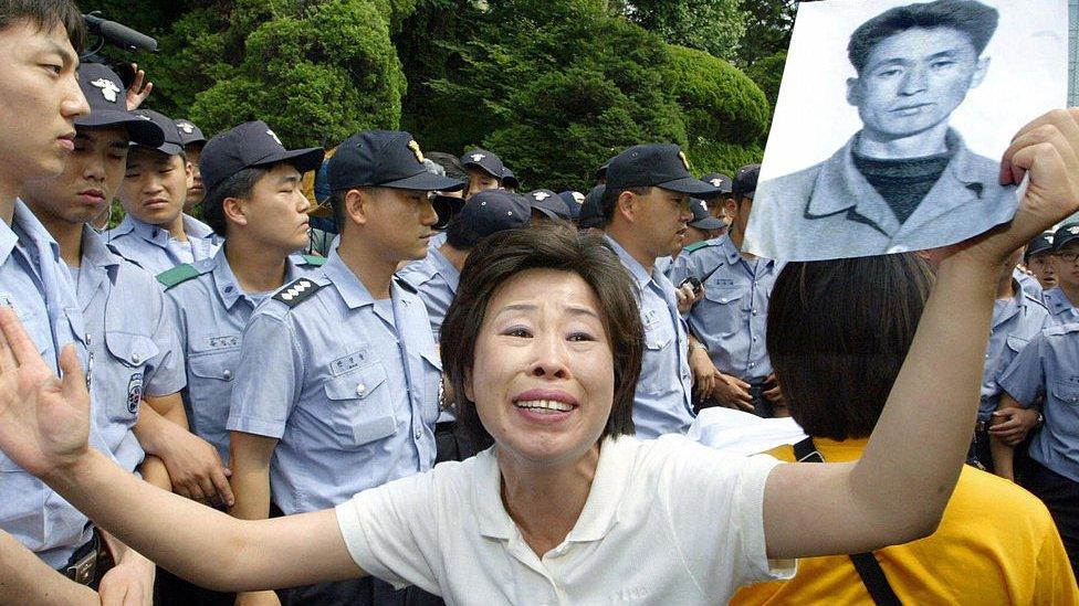 A Member of Korean War Abductees Family Union, Lee Yong-soon, a North Korean defector, holds a portrait of her father Lee Gyu-man, who died in North Korea after being taken prisoner during the war, outside a venue of South and North Koreas meeting in Seoul, 23 June 2005,