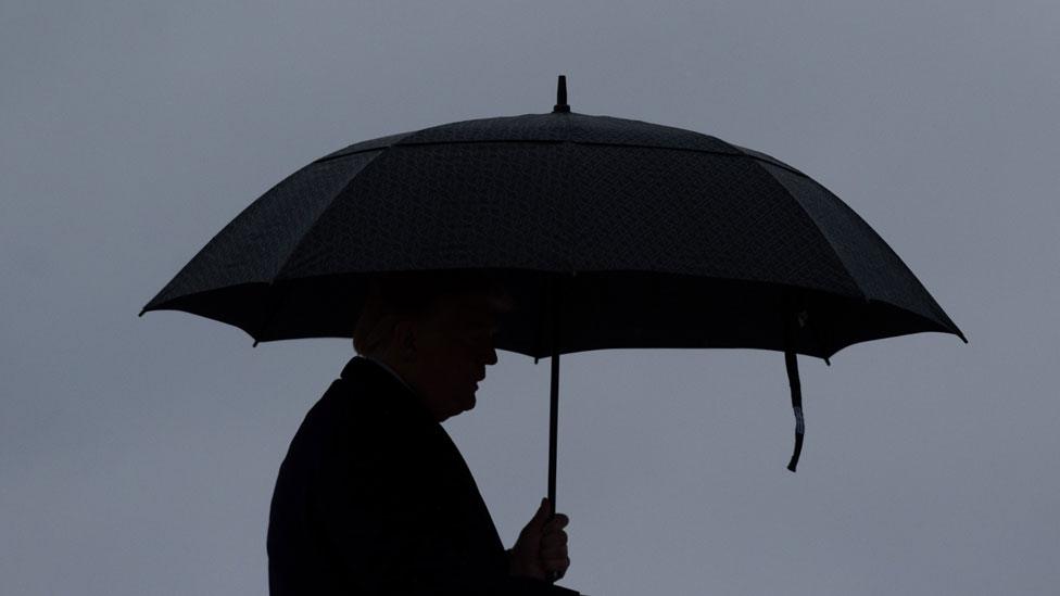 Trump under umbrella