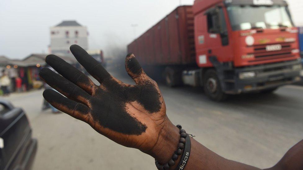 A man holds out his soot covered hand that he used to illustrate how much soot covered the bonnet of his car.