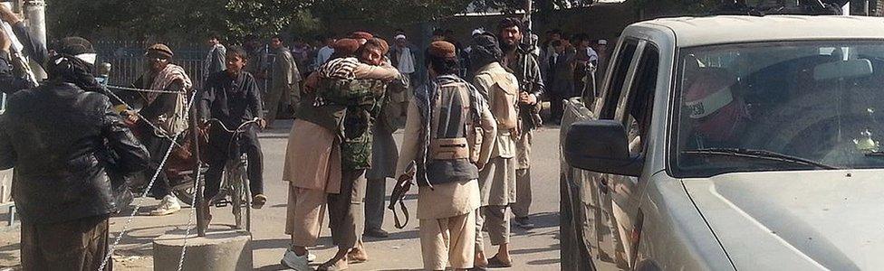 Taliban fighters hug each other a day after they overran the strategic northern Afghan city of Kunduz, on September 29, 2015.