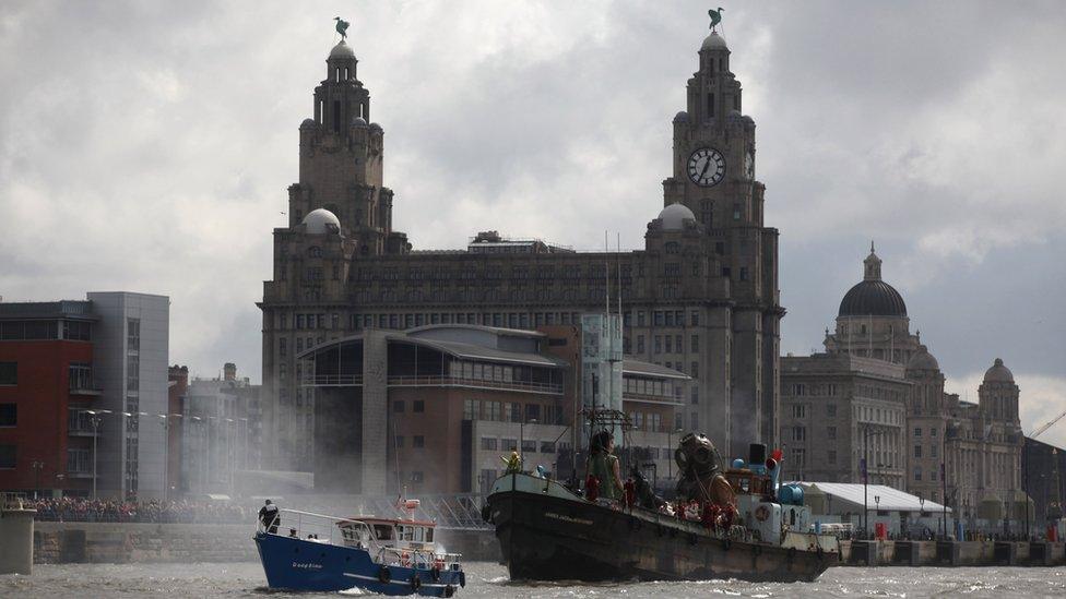 The giant deep sea diver, the little giant girl and her dog Xolo sail along the River Mersey